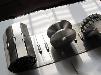 A round and a teeth sprockets are installed on the flat surface metal chain plate conveyor belt.