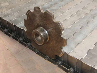 A single-pitch sprocket is installed on the flat surface metal chain plate conveyor belt.