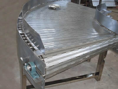 A conveying machine on the ground with curved flat bar chain plate belts.