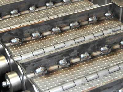 A piece of convex plate belt with transverse baffles, side plates and cotter pin chains on the ground.