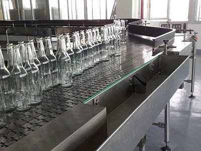Several empty bottles on the stainless steel flat top chain.