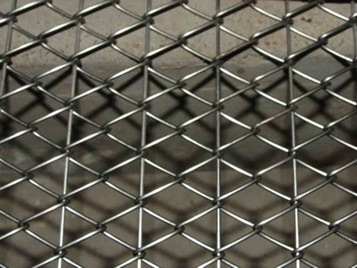 A piece of reinforced chain link oven mesh belt on the ground.