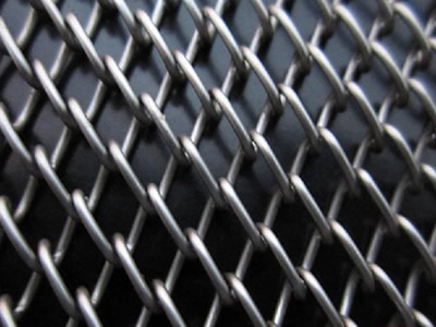 A piece of standard chain link oven mesh belt on the black background.