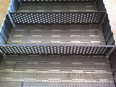 A piece of perforated surface chain plate conveyor belt with perforated plate transverse baffle on the ground.