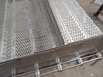A piece of steel chain plate conveyor belt with perforated chain plate, transverse baffle and three lane side plates on the ground.