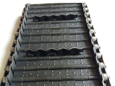 A piece of carbon steel convex surface chain plate conveyor belt with waving plate transverse baffle on the ground.